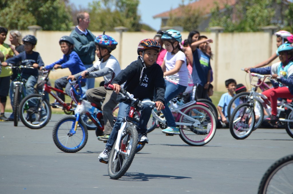 Elementary school child riding his bike through the bike rodeo course.