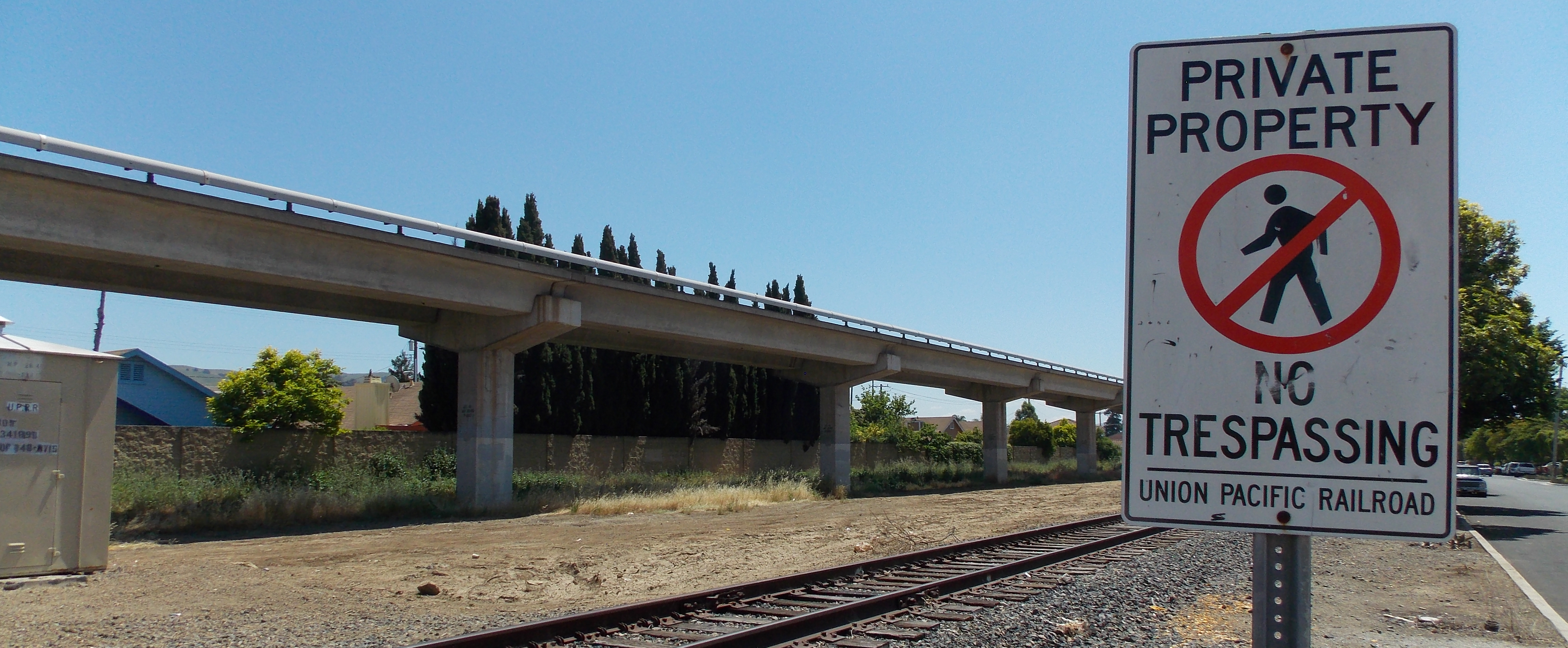 An image of a Union Pacific Railroad sign that reads 'Private Property No Trespassing' next to a railroad track. 