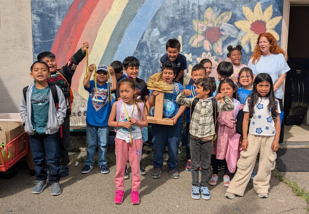 Students from Horace Mann Elementary pose with their Golden Sneaker trophy